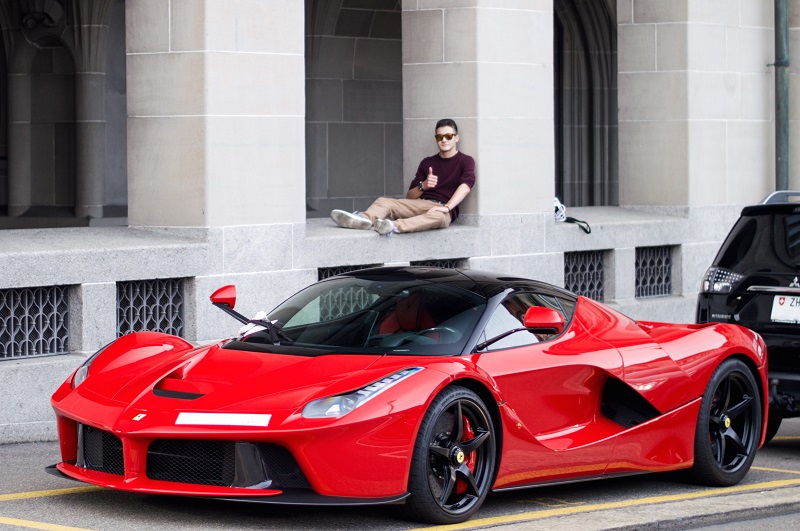 Der Fotograf Cédric Plattner sitzend, im Vordergrund ein Ferrari LaFerrari