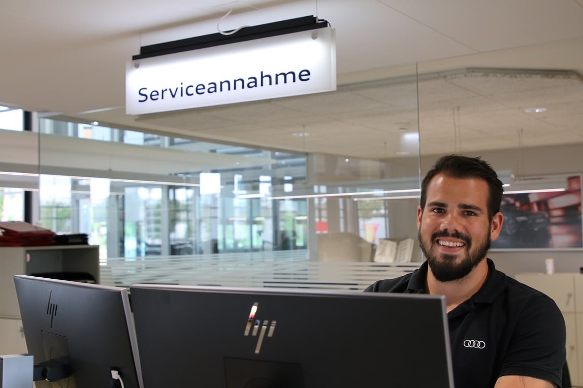 Philipp Frommelt an seinem Arbeitsplatz als Serviceberater Audi